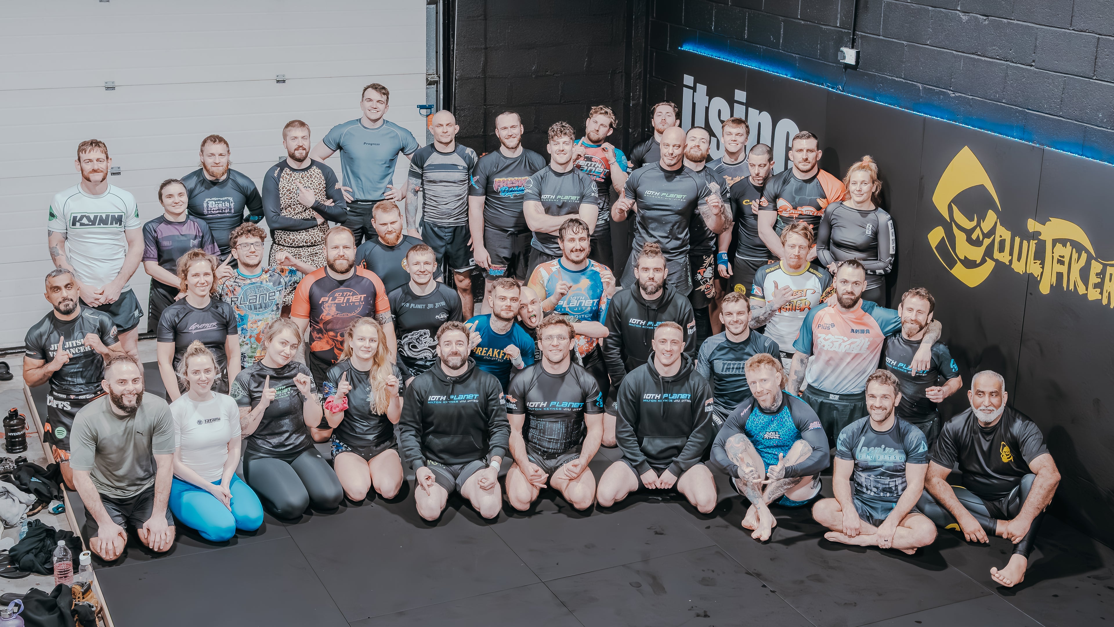 Group of people posing together in front of a wall..